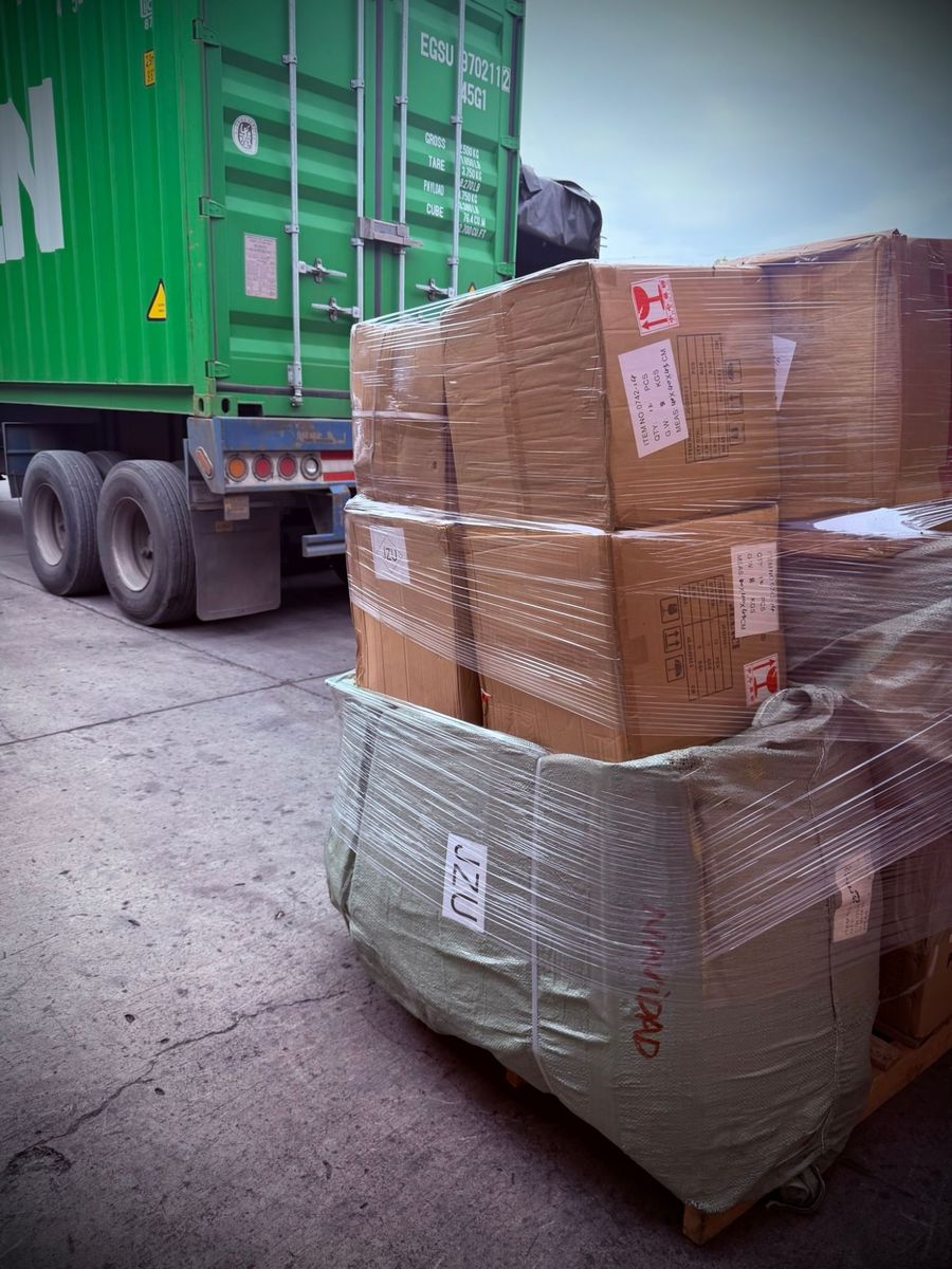 Estibas con cajas de importación junto al contenedor