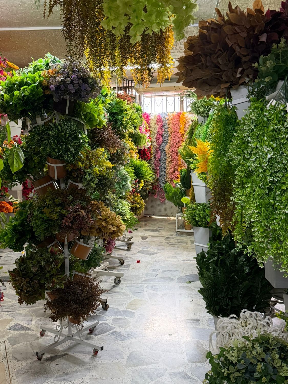 Pasillo del segundo piso de Decorflores lleno de flores y matas artificiales