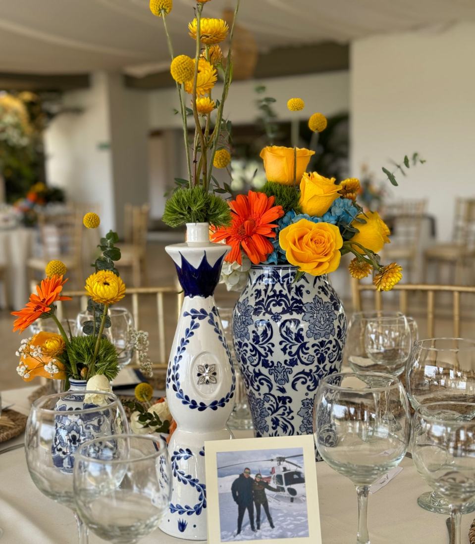 Centro de mesa con rosas amarillas y gerberas en jarrones azules