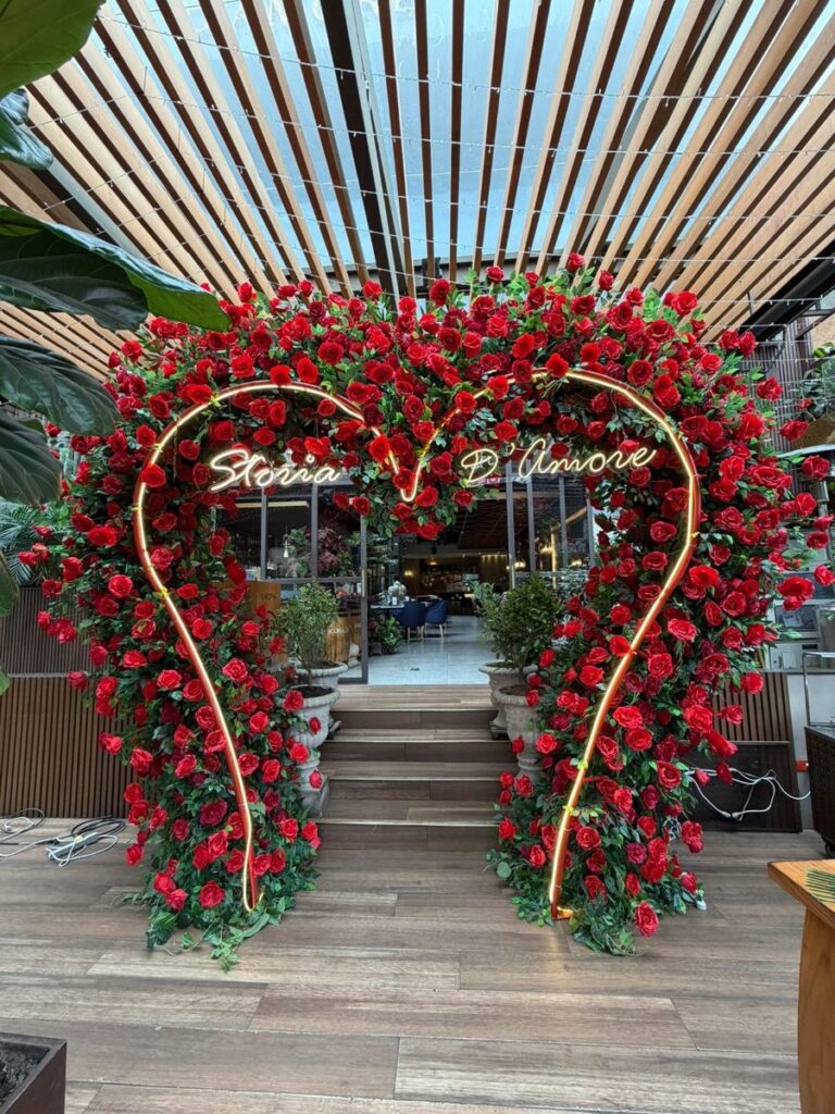 Corazón de rosas rojas con letrero de luz