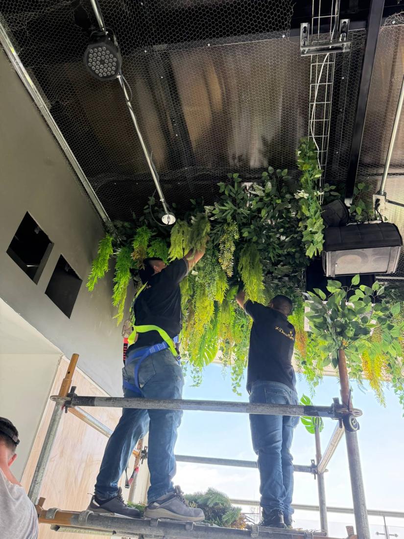 Equipo instalando un techo de follajes en andamio