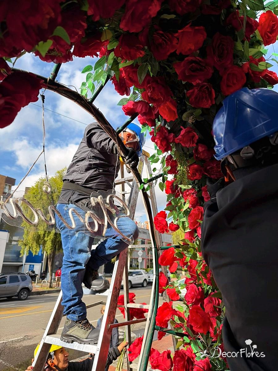Montador con casco en la escalera instalando el letrero de luz