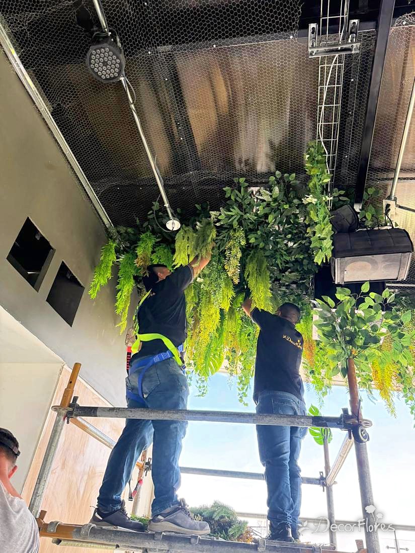 Equipo instalando un techo de follajes en andamio