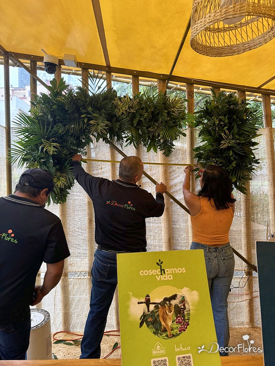 Equipo instalando follajes en un stand