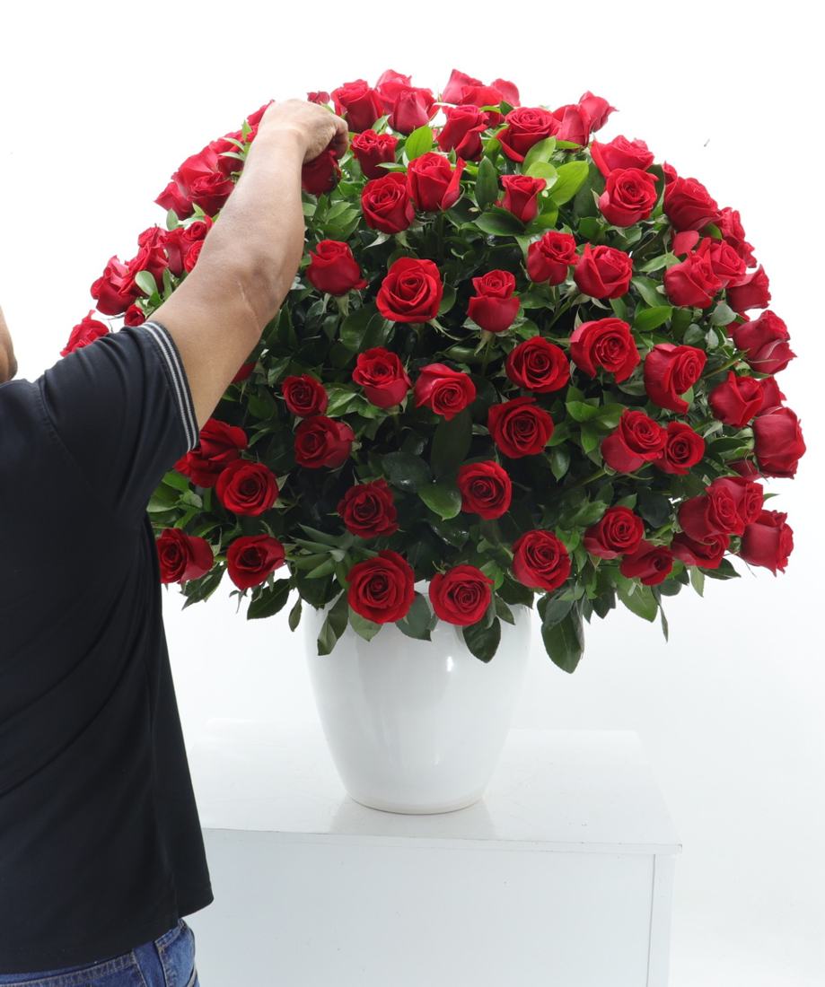 Florista armando un arreglo de rosas rojas